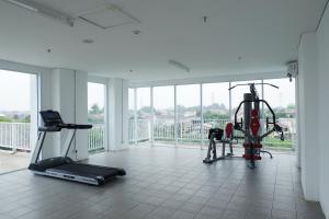 a gym with two treadmills and a treadmill at Comfy Studio Poris 88 Apartment By Travelio in Poris-lor