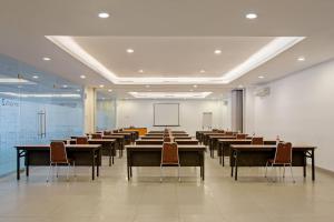 a large room with tables and chairs and a whiteboard at Carani Hotel Yogyakarta in Yogyakarta