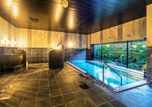 a large bathroom with a hot tub and a window at Hotel Route-Inn Katori Sawara Ekimae in Katori