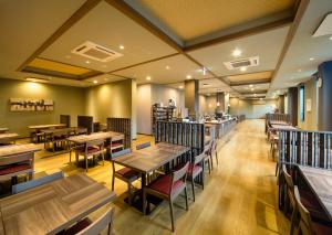 a restaurant with wooden tables and chairs and a cafeteria at Hotel Route-Inn Katori Sawara Ekimae in Katori