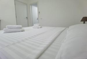 Una cama blanca con sábanas blancas y toallas. en Casa Sima, en Curtea de Argeş