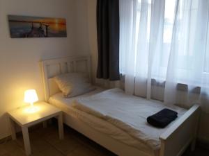 - une chambre avec un lit doté d'une lampe et d'une fenêtre dans l'établissement Appartement Confidence, à Bürstadt
