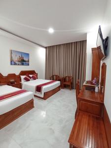 a hotel room with two beds and a television at Royal Hotel 2 in Bạc Liêu