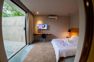 a bedroom with a bed and a desk and a tv at courtyard@TC in Kuantan