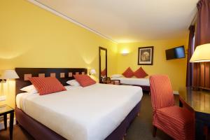 Hotel De La Jatte tesisinde bir odada yatak veya yataklar