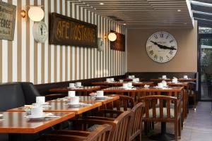 فندق دو لا جات في نويي سور سين: مطعم بطاولات خشبية وساعة على الحائط