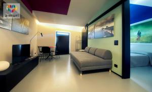 甘吉A-MURI的客厅里有一张沙发、一张床和一张桌子