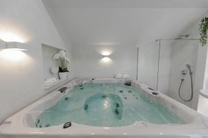 e bagno con vasca riempita di acqua blu. di Villa Bante - Luxury Stone House a Kaštela (Castelli)