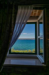 een raam met uitzicht op de oceaan bij Villa Bante - Luxury Stone House in Kaštela