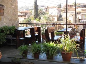 a patio with tables and chairs and potted plants at Vasilopoulos House in Tochni