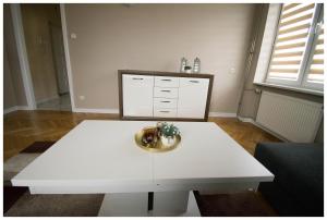 Biały stolik kawowy w salonie w obiekcie Color 24 Apartament III w mieście Stalowa Wola