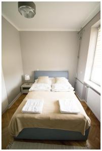 a bedroom with a bed with two towels on it at Color 24 Apartament III in Stalowa Wola