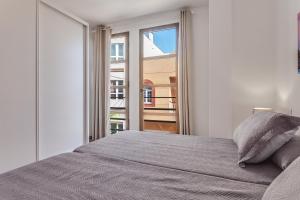 sypialnia z łóżkiem i dużym oknem w obiekcie Apartamento Pizarro 1b w Corralejo
