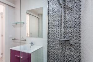 łazienka z umywalką i prysznicem z lustrem w obiekcie Apartamento Pizarro 1b w Corralejo