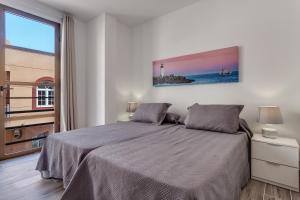 sypialnia z łóżkiem i dużym oknem w obiekcie Apartamento Pizarro 1b w Corralejo