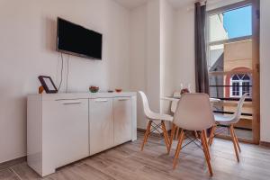 salon z telewizorem, stołem i krzesłami w obiekcie Apartamento Pizarro 1b w Corralejo