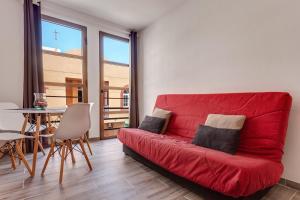 czerwoną kanapę w salonie ze stołem w obiekcie Apartamento Pizarro 1b w Corralejo