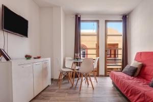 salon z czerwoną kanapą i stołem w obiekcie Apartamento Pizarro 1b w Corralejo
