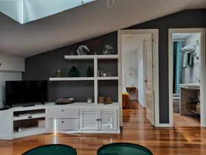 salon z białym centrum rozrywki z telewizorem z płaskim ekranem w obiekcie La casa de LA FLORA a 3 minutos de la catedral VUT09187 w mieście Burgos