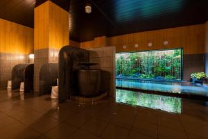 a swimming pool in a building with a large aquarium at Hotel Route-Inn Kanuma Inter in Kanuma