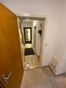 a hallway with a door and a tile floor at Einfaches Haus mit Privatzimmern und Gemeinschaftsräumen in Heilbronn