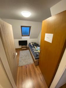 Kleines Zimmer mit einem Bett und einer Tür in der Unterkunft Einfaches Haus mit Privatzimmern und Gemeinschaftsräumen in Heilbronn