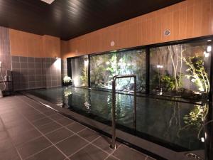 益田にあるホテルルートイン益田の水族館付きのバスルームのスイミングプール