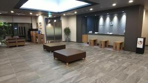 a lobby with a waiting area with couches and tables at Hotel Route-Inn Masuda in Masuda