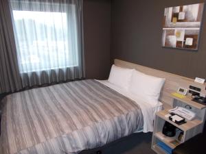 Voodi või voodid majutusasutuse Hotel Route-Inn Masuda toas