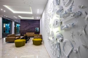 a lobby with couches and a wall with plates at Sentido Asterias Beach Resort in Afantou