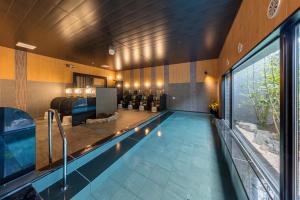 einen Pool in einem Haus mit einem Wohnzimmer in der Unterkunft Hotel Route-Inn Kurashiki Mizushima in Kurashiki