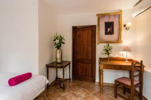 a room with a bed and a desk and a table at Agroturismo Can Pere Sord in Sant Joan de Labritja