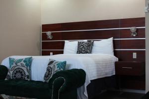 a bedroom with a large bed with a green couch at Hotel Cacaxtla in La Concordia