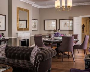 een woonkamer met een bank en een tafel met stoelen bij Four Seasons Hotel The Westcliff in Johannesburg