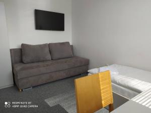 a living room with a couch and a tv at Penzion ValMez in Valašské Meziříčí