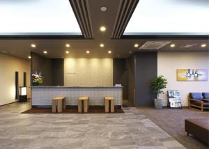 a lobby with a reception desk with two benches at Hotel Route-Inn Takefu Inter in Echizen-shi