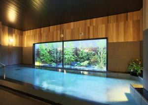 a swimming pool with a large window and a large aquarium at Hotel Route-Inn Takefu Inter in Echizen-shi