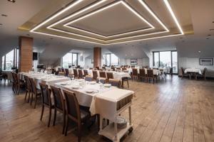 a restaurant with white tables and chairs and windows at BOLU GRAND KÖROĞLU OTEL in Bolu