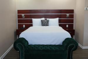 a bedroom with a large bed with a green tufted head board at Hotel Cacaxtla in La Concordia