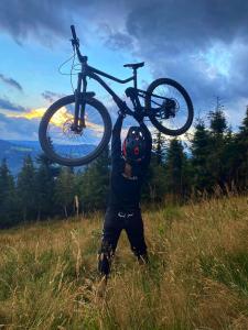 a person holding a bike on top of a hill at Poziomkowa Chata Szczyrk in Szczyrk
