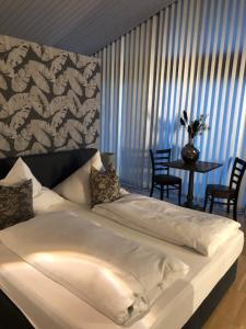 een slaapkamer met een wit bed met een tafel en stoelen bij Residence in Chieming