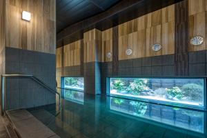 千葉市にあるホテルルートイン千葉浜野-東京湾岸道-の木造の壁の建物内のスイミングプール