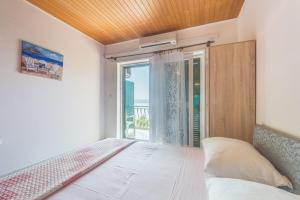 a bedroom with a bed and a large window at Apartments Kod Cara in Lokva Rogoznica