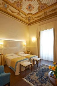 a hotel room with two beds and a ceiling at Hotel Firenze Capitale in Florence