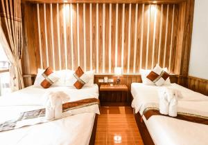 two beds in a hotel room with white sheets at Wang Sai Resort - SHA Plus in Mae Haad