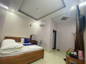 ein Schlafzimmer mit einem Bett und einem TV. in der Unterkunft Van Anh Motel in Cốc Lếu