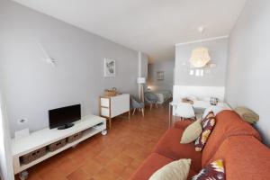a living room with a couch and a tv at Desconnectar Tossa de Mar in Tossa de Mar