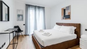 a bedroom with a bed with white sheets and a desk at Italianway - Lazzaro Papi 14 A in Milan
