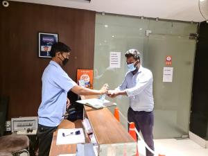 two men are shaking hands at a table at Hotel Star Inn in Gangānagar