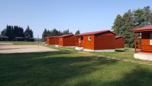 a row of wooden cabins in a park at Růžená - chatky u rybníka in Milevsko +2 photos